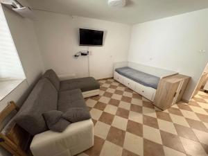a living room with a couch and a tv at Apartma Studio Enej Piran in Piran