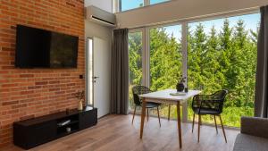 a living room with a table and chairs and a large window at Flatbook Stegna Południowa Apartamenty z Basenem in Stegna +28 photos