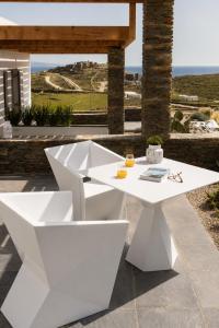 a white table on a patio with a view of the ocean at Elements Sifnos in Sifnos
