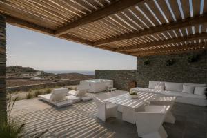 a patio with white furniture and a table and chairs at Elements Sifnos in Sifnos