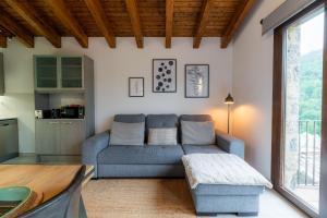 a living room with a blue couch and a table at Can Pont in Camprodon