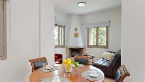 a living room with a table and a couch at Epidavros Villas - Dafni Stone & Garden Retreat in Nea Epidavros