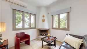 a living room with a couch and a fireplace at Epidavros Villas - Dafni Stone & Garden Retreat in Nea Epidavros