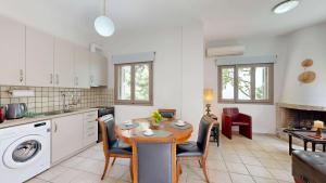 a kitchen and dining room with a table and chairs at Epidavros Villas - Dafni Stone & Garden Retreat in Nea Epidavros +17 photos