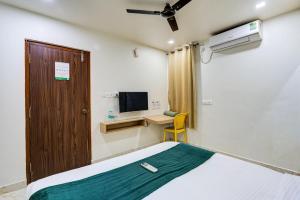 a room with a bed and a desk and a television at Hotel Elmas in Bangalore +48 photos