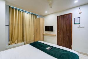 a hotel room with a bed and a television at Hotel Elmas in Bangalore