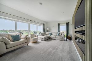 a living room with couches and a flat screen tv at Seaddler in Holyhead
