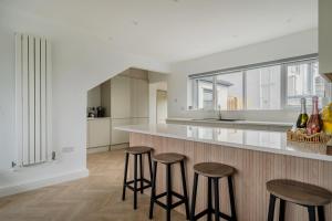 a kitchen with three bar stools and a counter at Seaddler in Holyhead