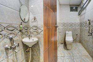 a bathroom with a sink and a toilet at Hotel Elmas in Bangalore