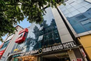a building with a sign that reads alums grand hotel at Hotel Elmas in Bangalore
