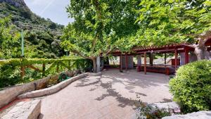 a brick patio with a pavilion with a tree at Epidavros Villas Voukamvilia Retreat, Shared Pool in Nea Epidavros +15 photos