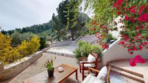 a patio with a table and chairs and flowers at Epidavros Villas Voukamvilia Retreat, Shared Pool in Nea Epidavros