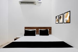 a bedroom with a white bed with black pillows at Hotel O JIND RESORT in Jīnd