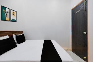 a bedroom with a black and white bed and a door at Hotel O JIND RESORT in Jīnd