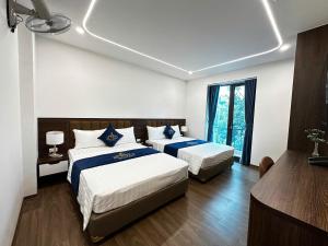 a hotel room with two beds and a window at A3 Villa Hotel - Gia Lâm in Thạch Cầu +10 photos