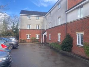 a parking lot with cars parked in front of a building at Friars terrace in Stafford +2 photos