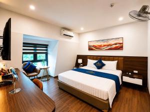 a bedroom with a bed and a desk and a television at A3 Villa Hotel - Gia Lâm in Thạch Cầu