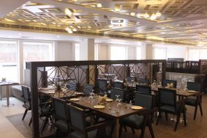 a dining room with tables and chairs and ceilings at Maya Heritage in Bodh Gaya