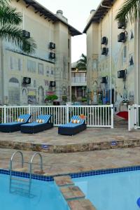 a pool at a hotel with blue beds next to a building at Uvongo River Resort by MyResorts in Margate