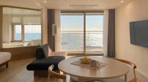 a living room with a table and a couch at Plott Archive Jeju in Jeju +129 photos