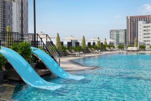 a swimming pool with two blue slides in the water at Dusit Princess Melaka in Malacca +39 photos