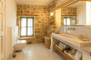 a bathroom with a sink and a toilet and a mirror at İda Blue Adatepe in Küçükkuyu +96 photos