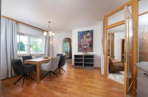 a dining room with a table and chairs and a painting at Bergvilla-Ramsau in Ramsau am Dachstein