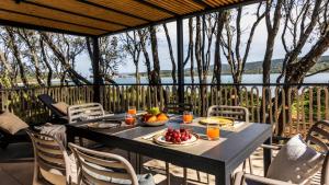 a table with food and drinks on a balcony with a view at Mobile Homes Lopari in Nerezine