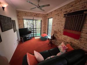 a living room with a couch and a brick wall at Avalon in Arcadia