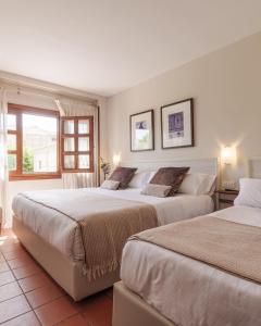 two beds in a room with two windows at Hotel San Antonio el Real in Segovia +80 photos
