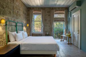 a bedroom with a bed and two windows at İda Blue Adatepe in Küçükkuyu