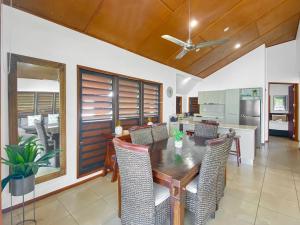 a kitchen and dining room with a wooden table and chairs at Pure Magnetic Villa 9 in Nelly Bay +20 photos