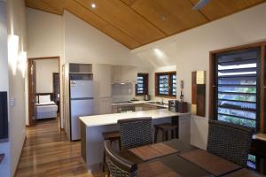 a kitchen with a counter and a table and chairs at Pure Magnetic Villa 8 in Nelly Bay