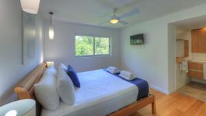 a bedroom with a bed with blue and white pillows at Maggies Beachfront Apartment 8 in Horseshoe Bay