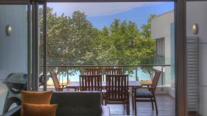 a patio with a table and chairs on a balcony at Maggies Beachfront Apartment 8 in Horseshoe Bay