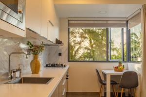a kitchen with a sink and a table with chairs at Pulsera Beach Residence Maldives by Circles Hospitality in Hulhumale