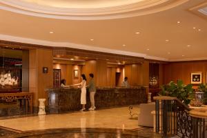 a couple standing at a bar in a hotel lobby at Dusit Princess Melaka in Malacca