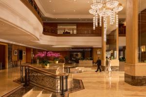 a man and woman walking through a lobby at Dusit Princess Melaka in Malacca