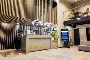 a man standing at a counter in a lobby at JET Hotel Lipa City in Lipa
