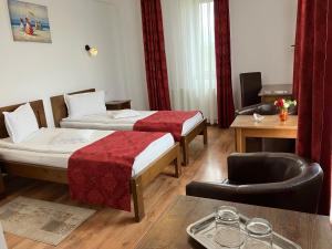 a hotel room with two beds and a chair at Pensiunea Cetatea Craiului in Râşnov +58 photos