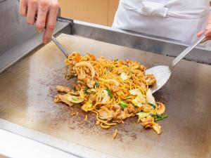 a person with two utensils in a pile of food at Hotel Keihan Kyobashi Grande in Osaka