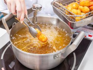 a person is stirring a pan with a spoon at Hotel Keihan Kyobashi Grande in Osaka