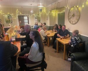 a group of people sitting at tables in a restaurant at The Bognie Inn in Huntly +7 photos