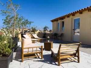 a patio with chairs and tables and a house at Deluxe Center Suites in Chania