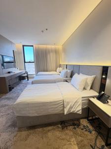 a hotel room with two beds and a desk at فندق سدو بوتيك التحلية in Medina