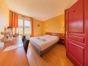 a hotel room with a bed and a desk and a table at Le Relais du Mess in Vacherauville