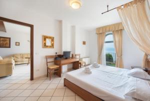 a bedroom with a bed and a desk with a computer at ApartmentsGarda - Villa Giada in Torri del Benaco +61 photos