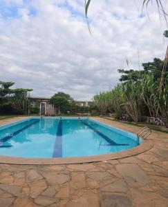 a swimming pool with blue water in a yard at Lesha Park Hotel in Libwezi