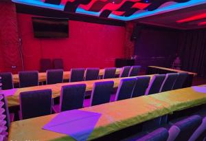 a room with a table and chairs and a red wall at Lesha Park Hotel in Libwezi