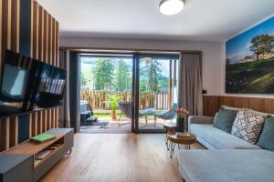 a living room with a couch and a tv at Gora Luxury Apartments in Kranjska Gora
